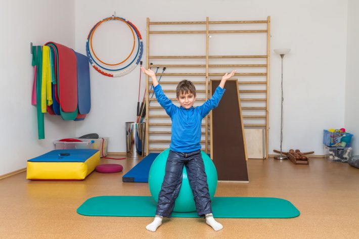 Child is therapeutic exercises in the gym